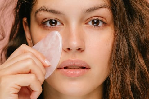 Woman Using a Rose Quartz Gua Sha on Her Face