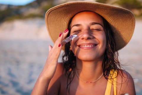 woman applying sunscreen while outside 