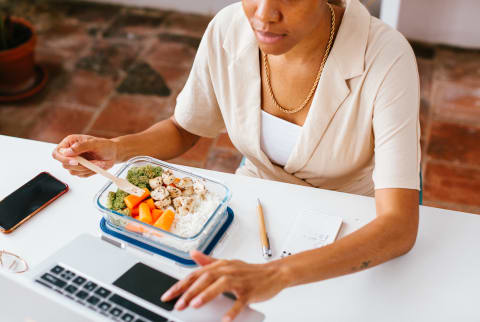 Unrecognizable Woman Eating at Her Desk