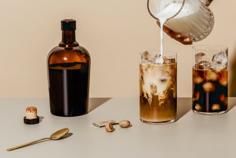 Hand Pouring Milk Into Cold Brew Coffee