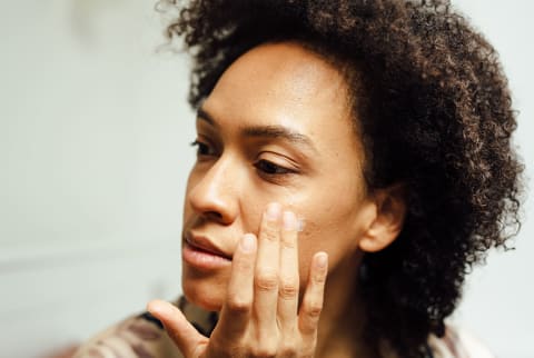 Close Up Of A Woman Putting Lotion On Her Face