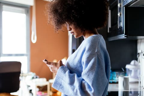 Woman in the kitchen with a cup of coffee